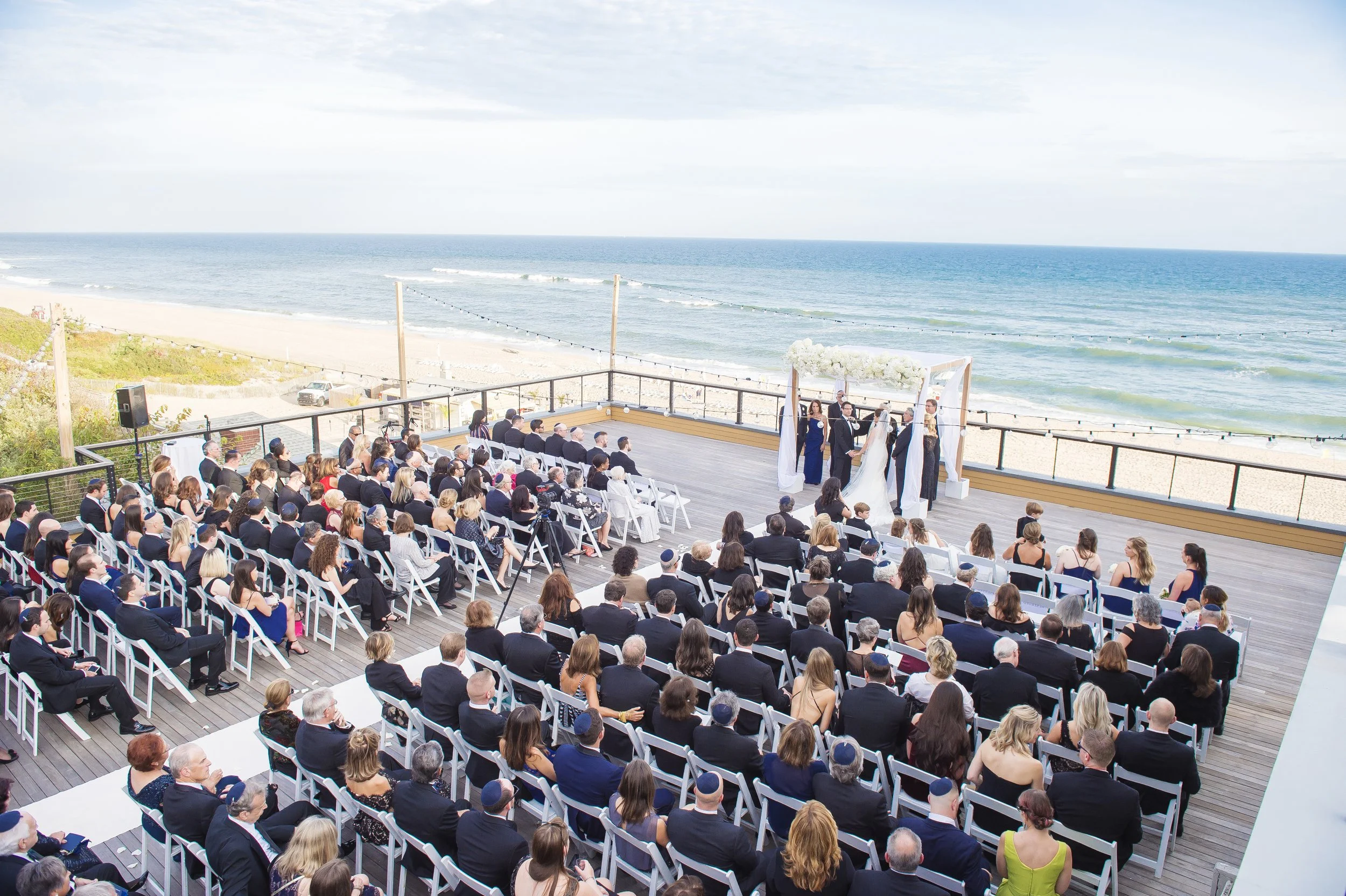 Beachfront Wedding Ceremony with White Floral Arch Planned by Faith Ferguson Productions