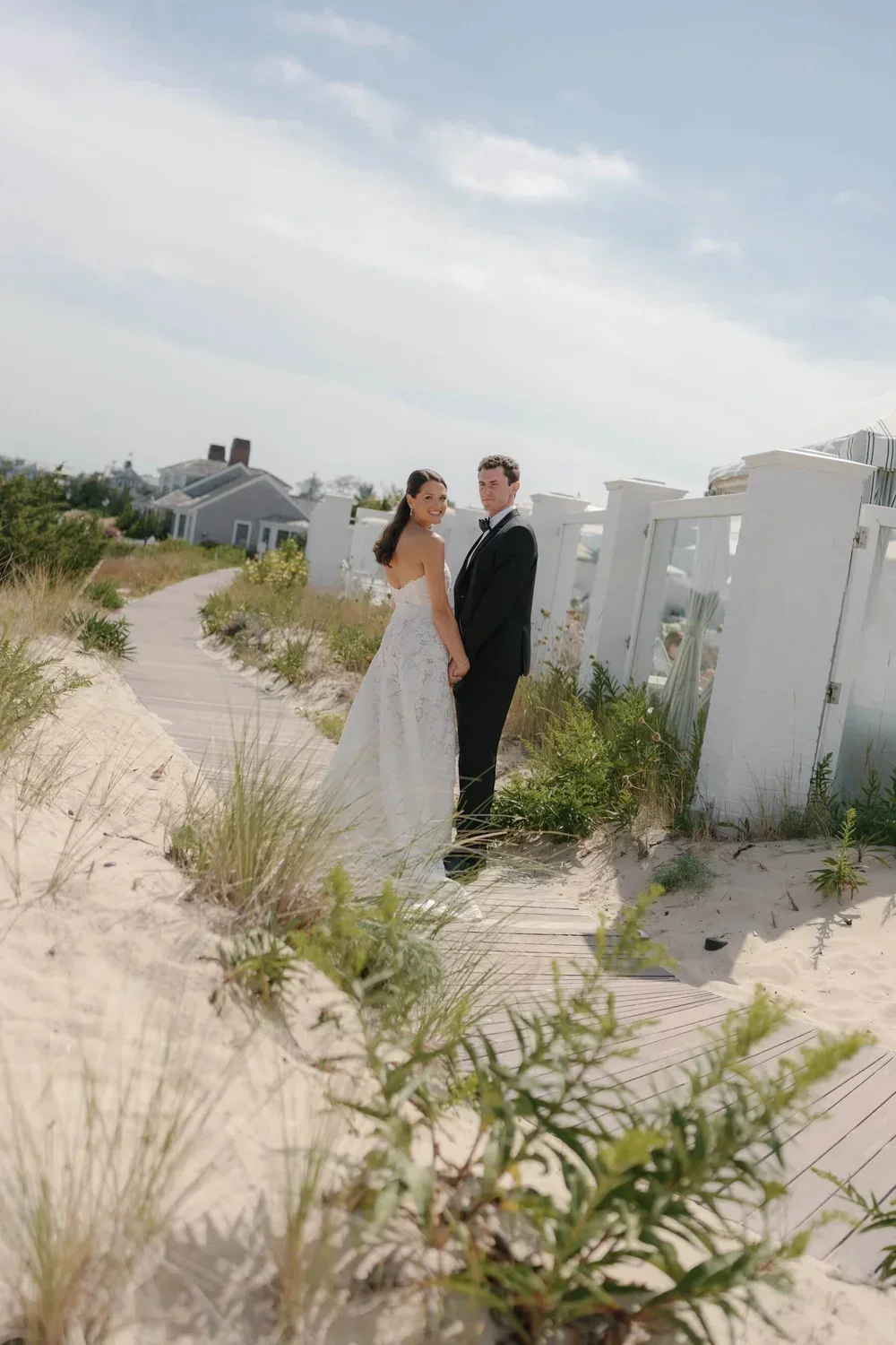 Bride and Groom Walking Along a Beach Path at a Coastal Wedding Planned by Faith Ferguson Productions