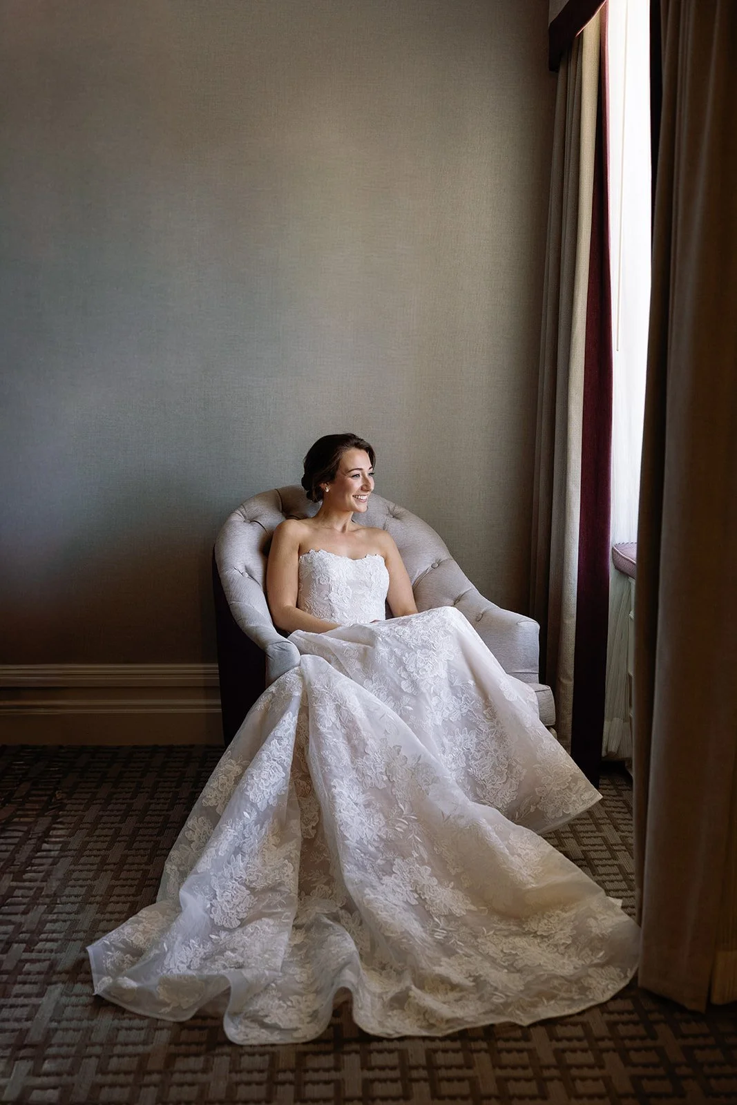 Bride in Wedding Gown Sitting on a Chair by a Window