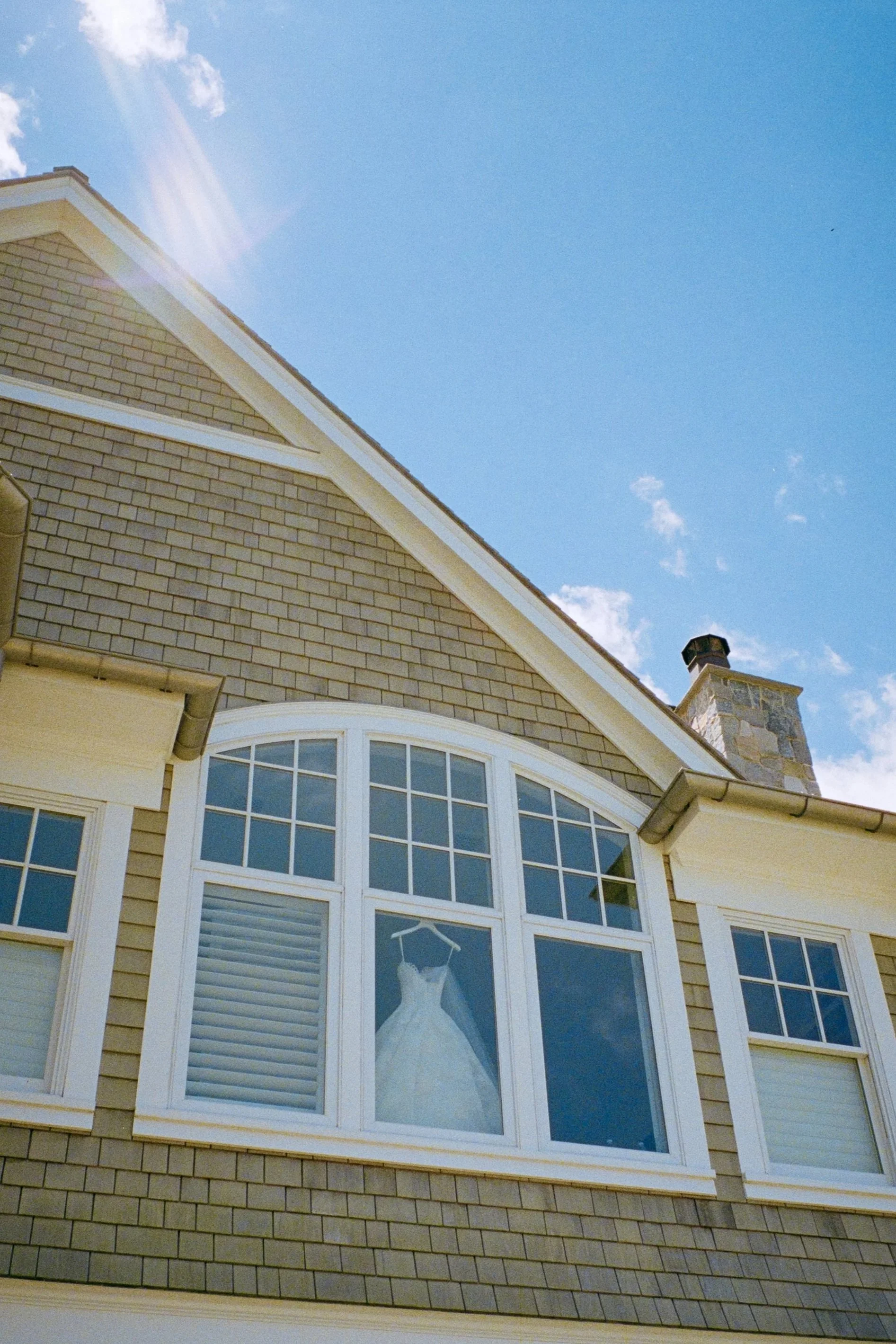 Wedding Dress Hanging in the Window of a Private Estate at a Luxury Wedding Planned by Faith Ferguson Productions
