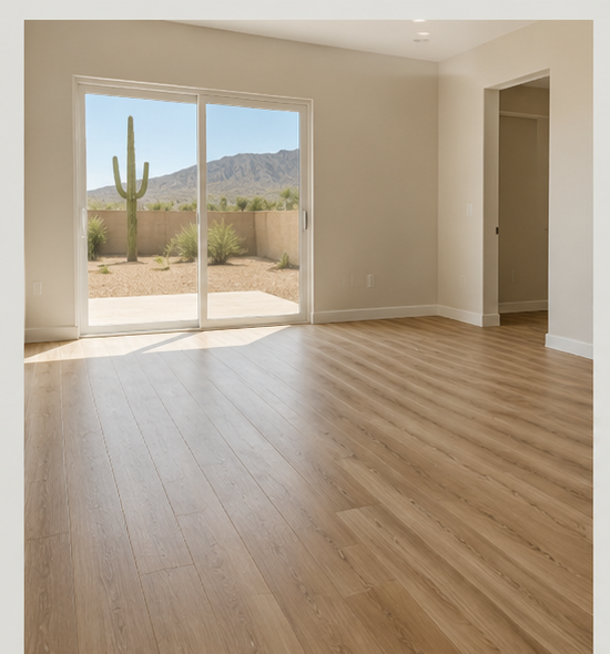 Empty living room with large sliding glass door opening to desert landscape with a cactus and mountains.