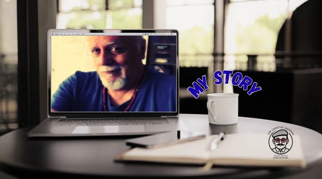 Image of a work table with a open laptop showing a portrait of Shane Garton.