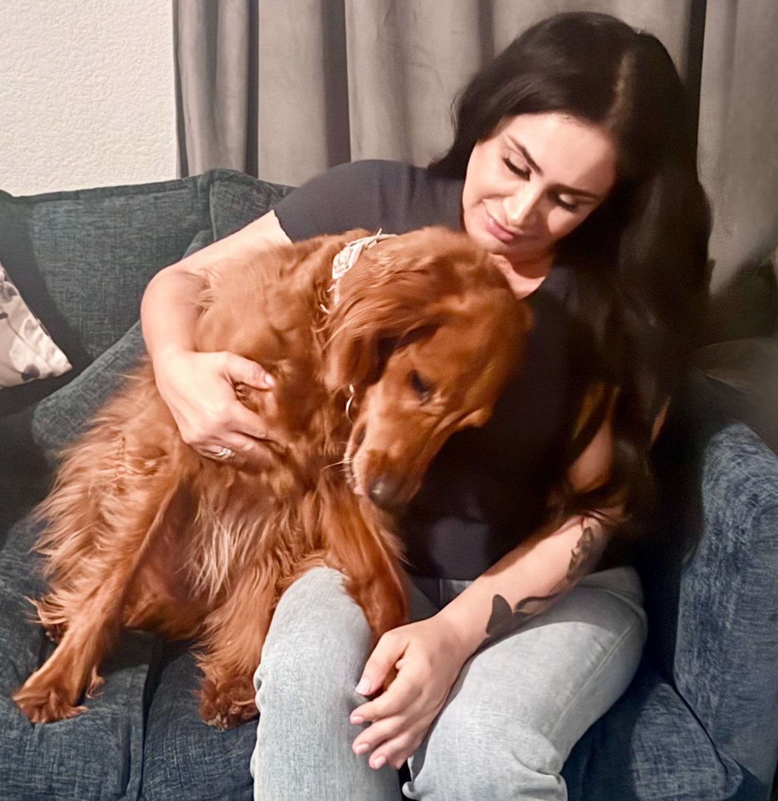 Bahareh Saidian hugging her large golden retriever dog resting its head on her lap.