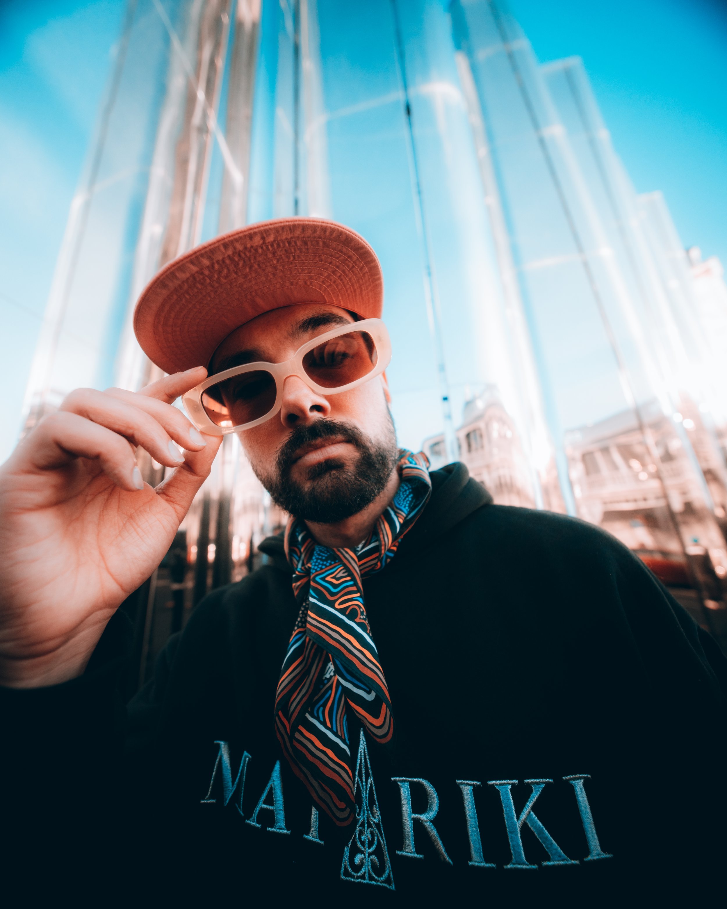 A press photo of Rei, male artist, wearing sunglasses and looking at the camera.