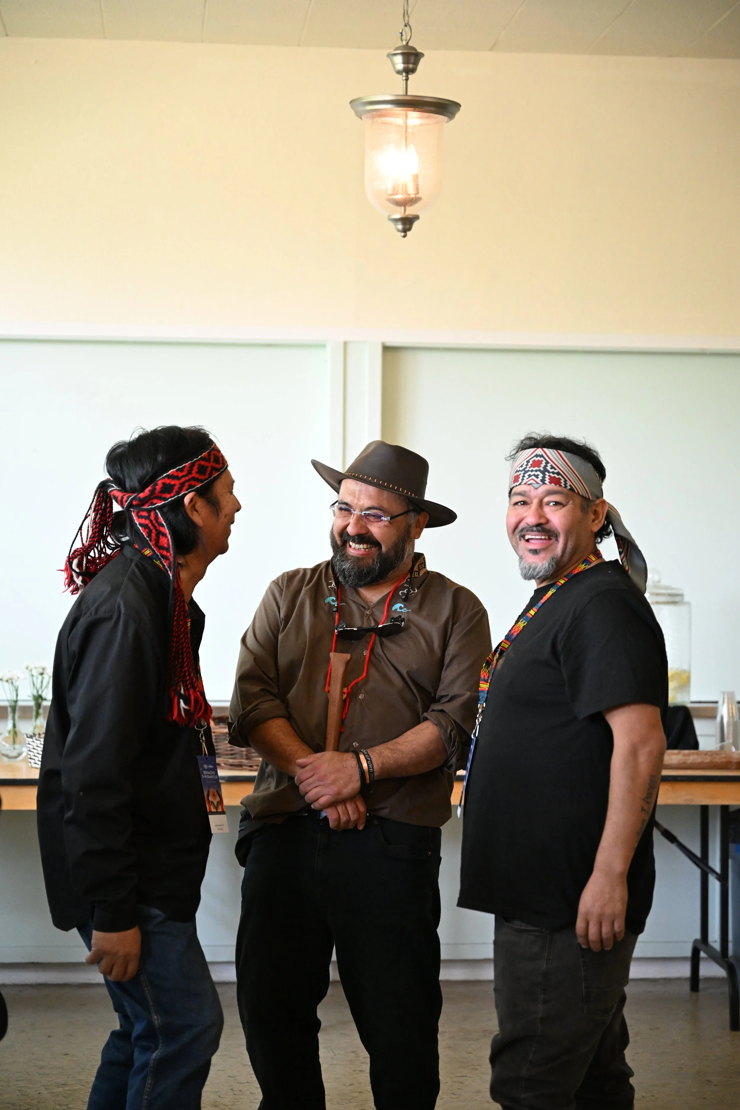 Three musicians from South America share a candid moment of laughter during a break from indoor activites at IIMS.