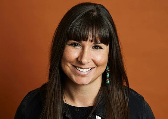 A photo of Nicole Auger smiling at the camera. She has dark, straight hair with bangs.