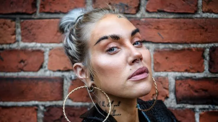 A press headshot of female artist Maxida Marak wearing large gold hoop earrings.