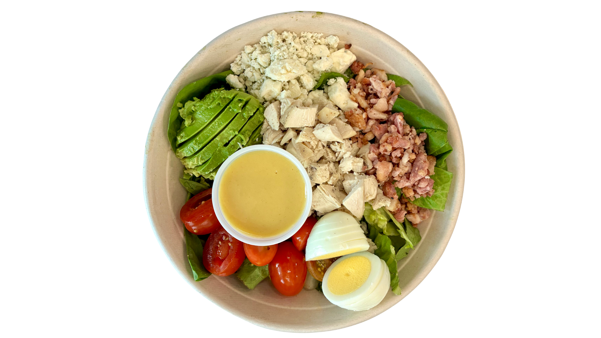 Bowl of salad with sliced avocado, cherry tomatoes, hard-boiled egg, chopped chicken, bacon bits, crumbled blue cheese, and salad dressing on a bed of lettuce.