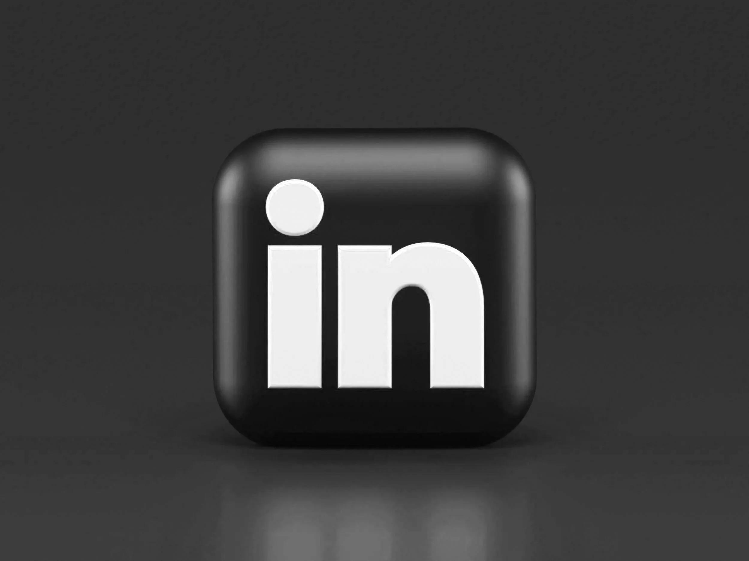 Close-up of a mobile phone icon with a dark background, focusing on the corner with a rounded edge and a white dot near the top left.