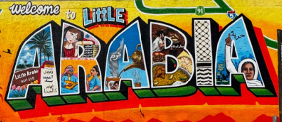 Colorful mural featuring the word 'DABLA' with various illustrations inside each letter, including desert scenes, animals, and people, welcoming visitors to Little Arabia in Little Rock.