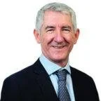 Professional portrait of a smiling middle-aged man in a suit and tie
