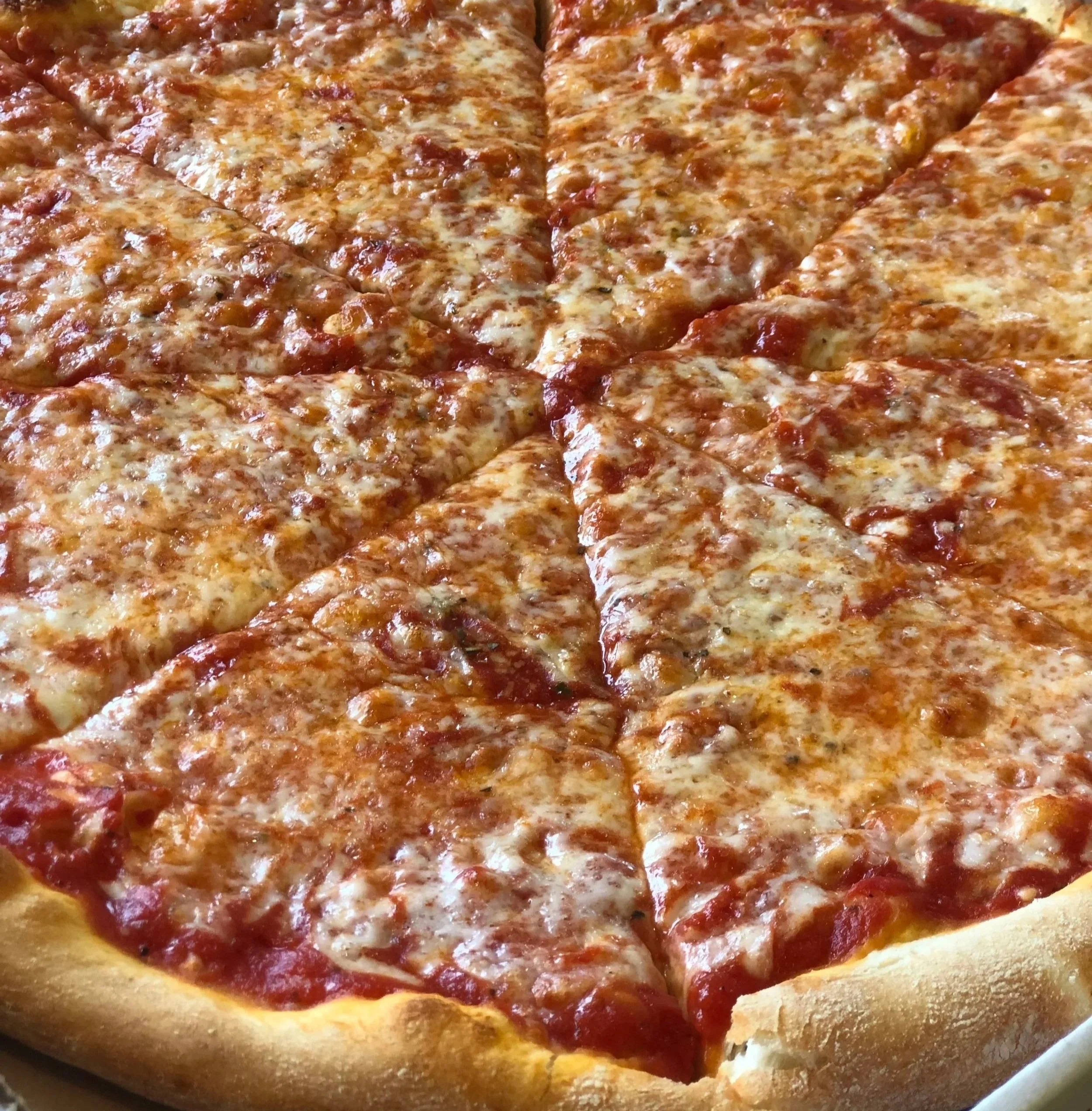 Close-up of a cheese pizza with a few slices cut and missing, showing melted cheese, tomato sauce, and pepperoni toppings.