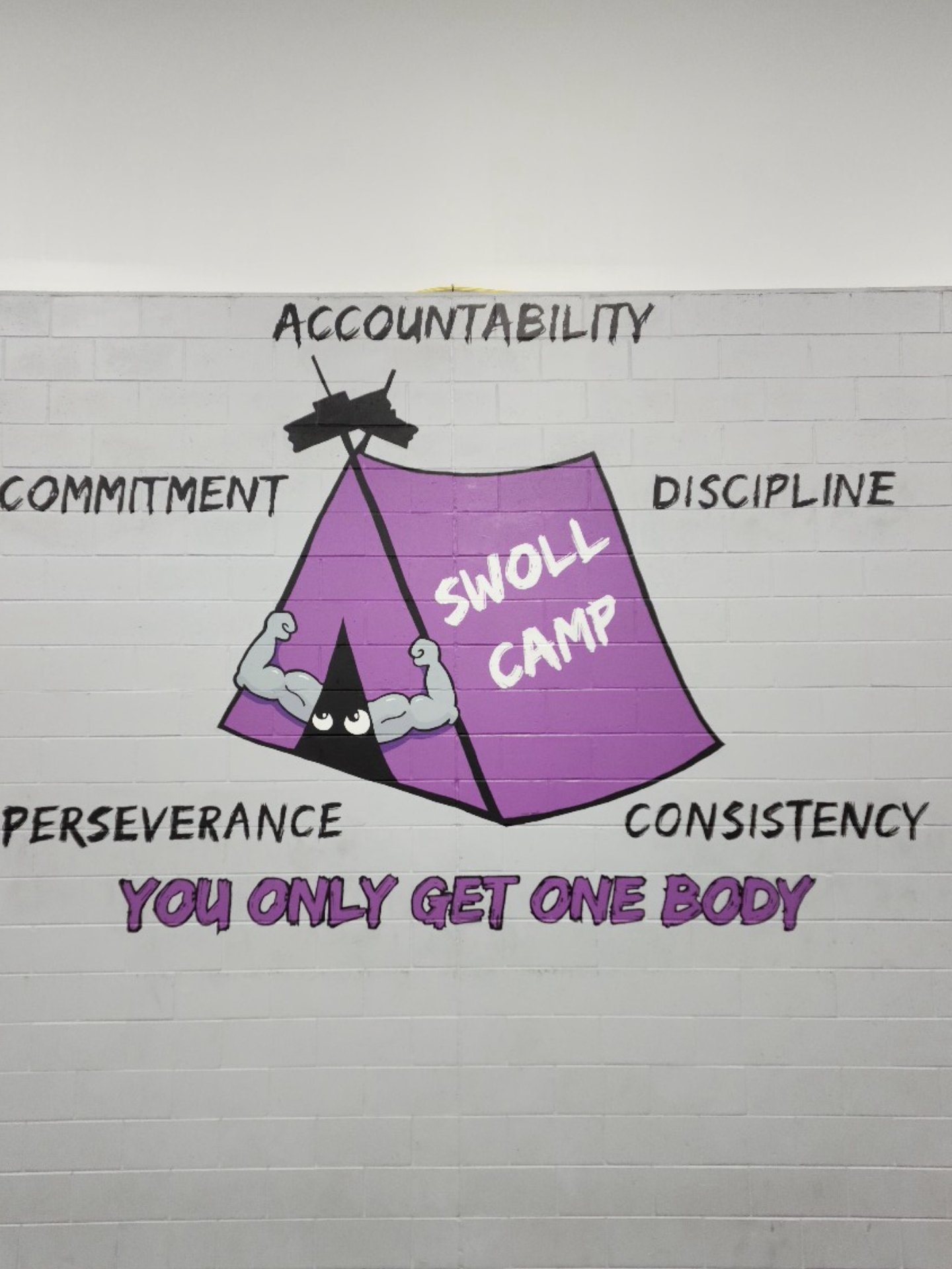 Swoll Camp logo mural at Wiregrass Ranch Sports Campus with 5 pillars. Accountability, Commitment, Discipline, Consistency, Perseverance. You Only Get One Body