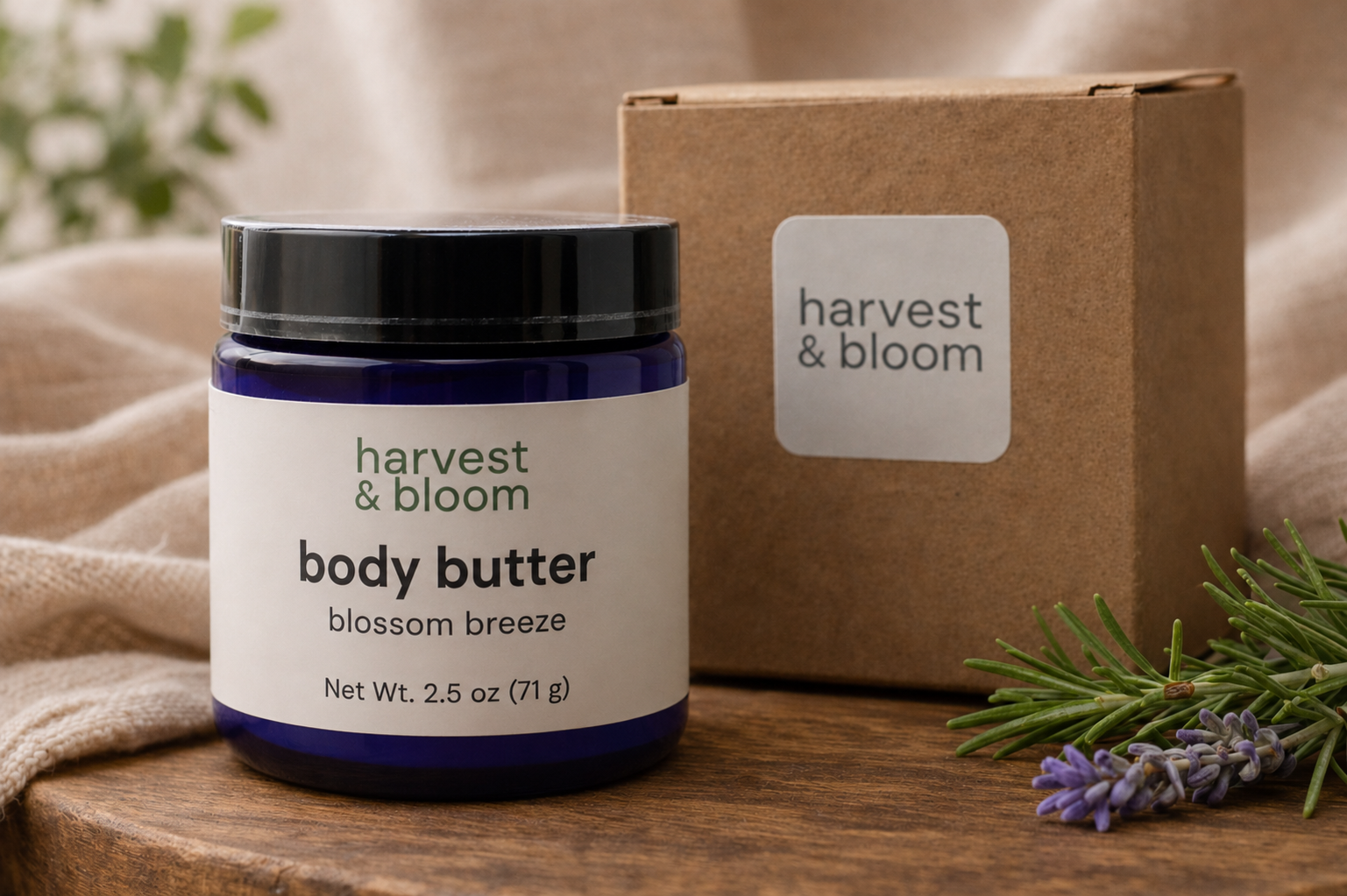 A blue glass jar of Blossom Breeze whipped tallow body butter alongside a natural kraft paper gift box on a rustic background.
