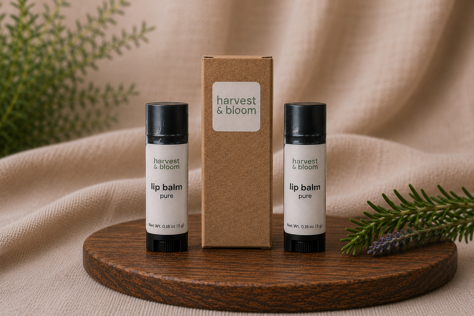 Two tubes of Harvest and Bloom natural lip balm standing next to a minimalist kraft paper product packaging box on a wooden tray.
