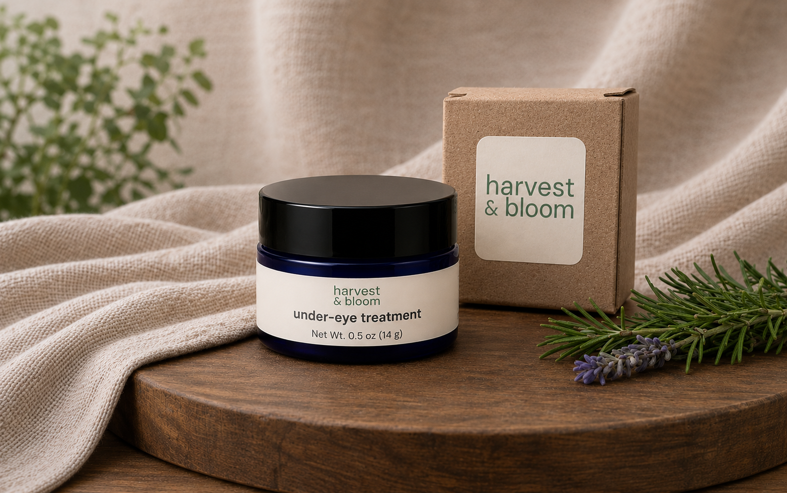 A half-ounce jar of botanical under-eye cream balm standing on a wooden platter next to its minimalist kraft paper product packaging box.