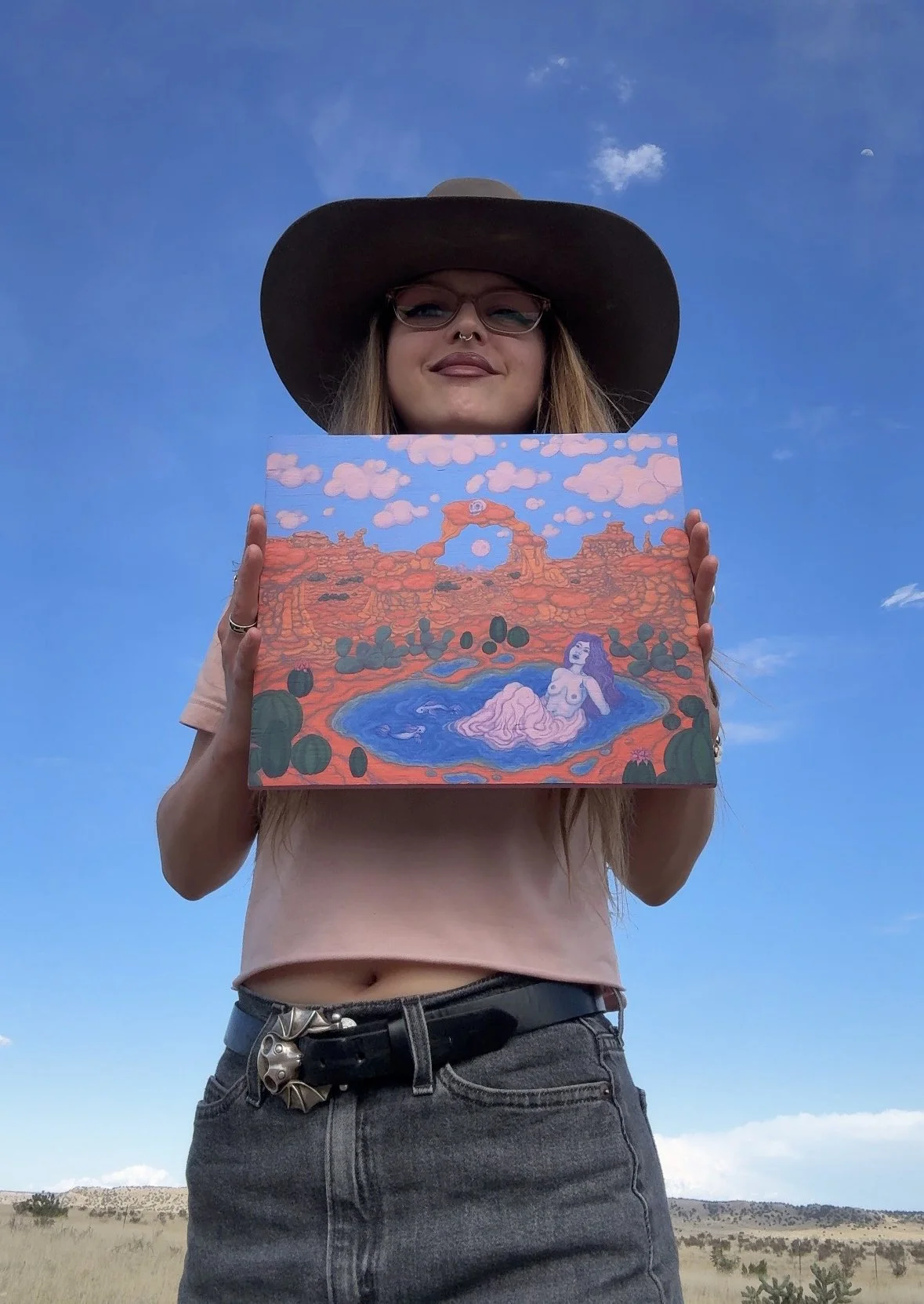 Nix holds her painting lady oasis in below an open sky