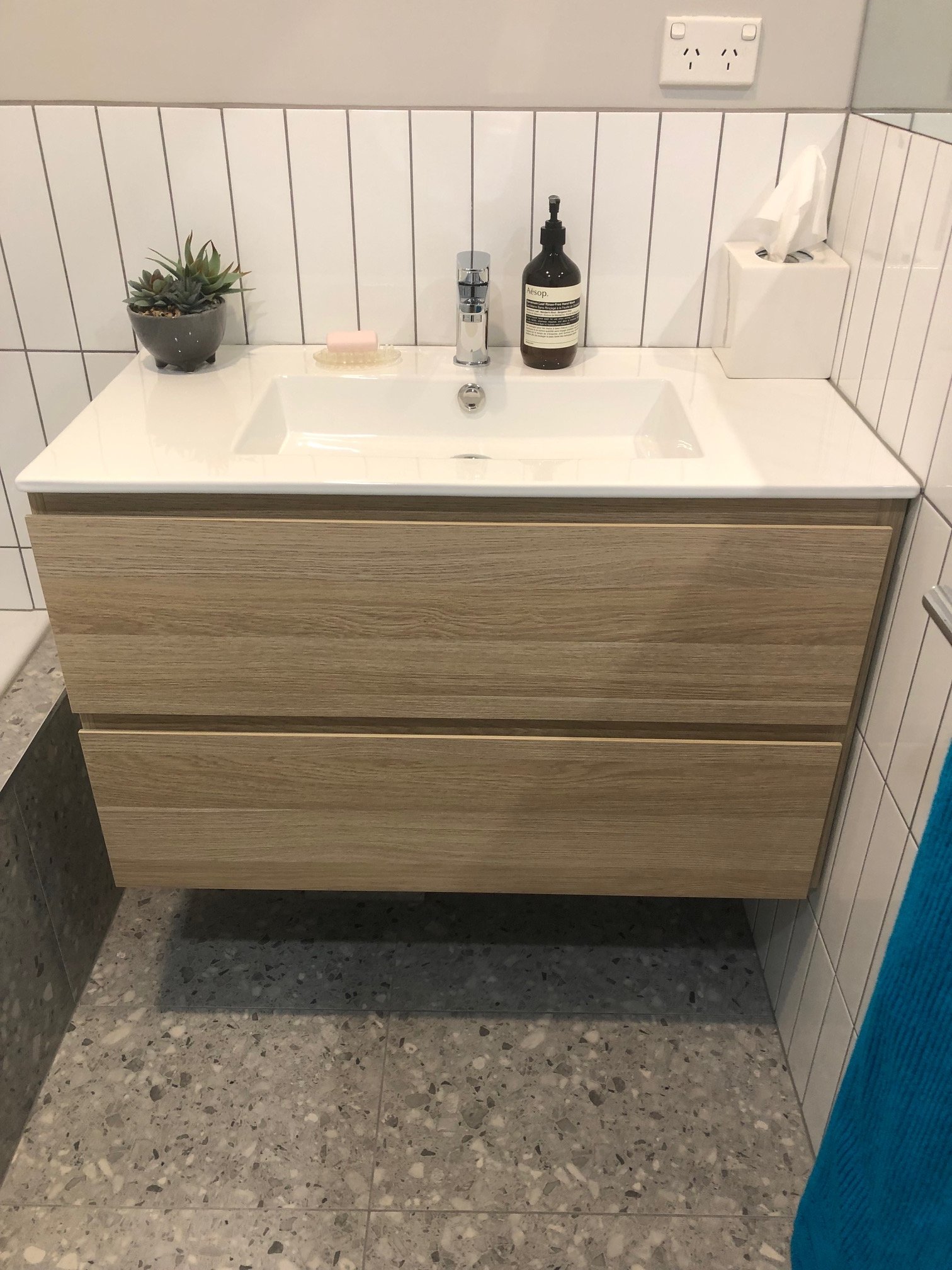 Modern bathroom vanity with white sink, chrome faucet.