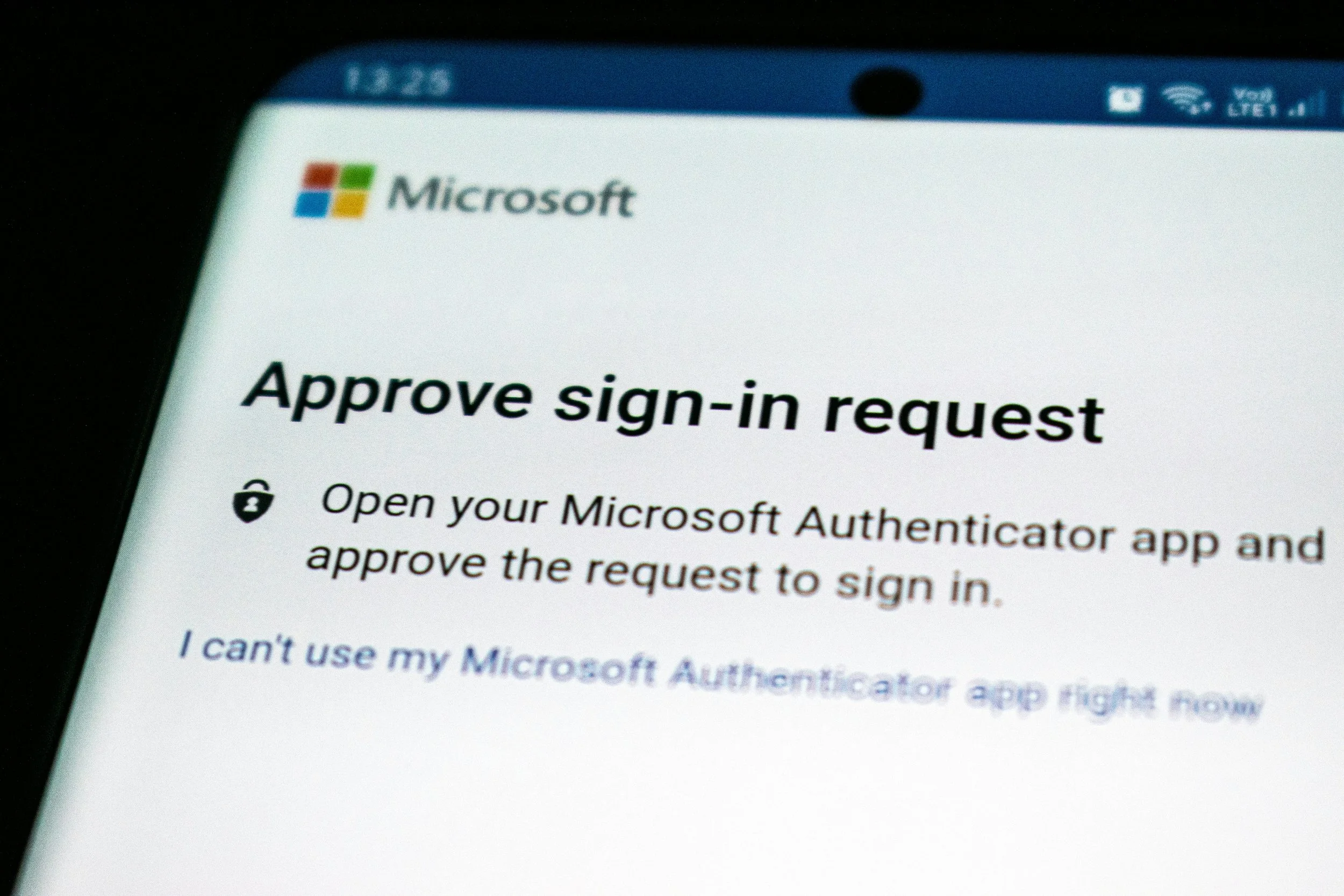 A phone screen displaying a Microsoft "Approve sign-in request" prompt, asking the user to open the Authenticator app.