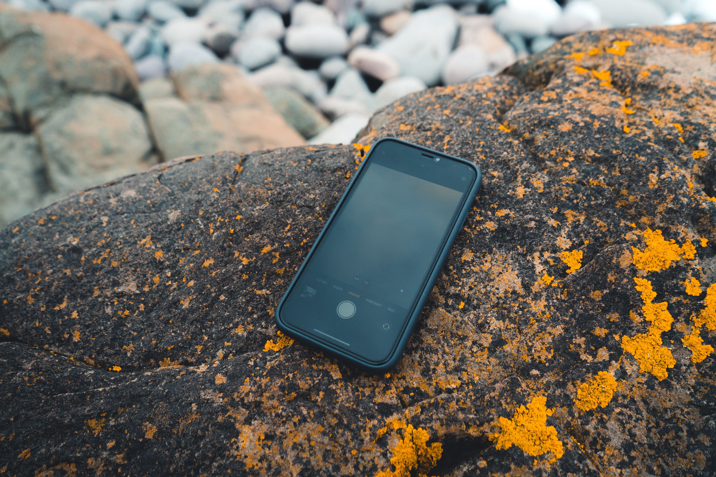 A smartphone lying on a rock.