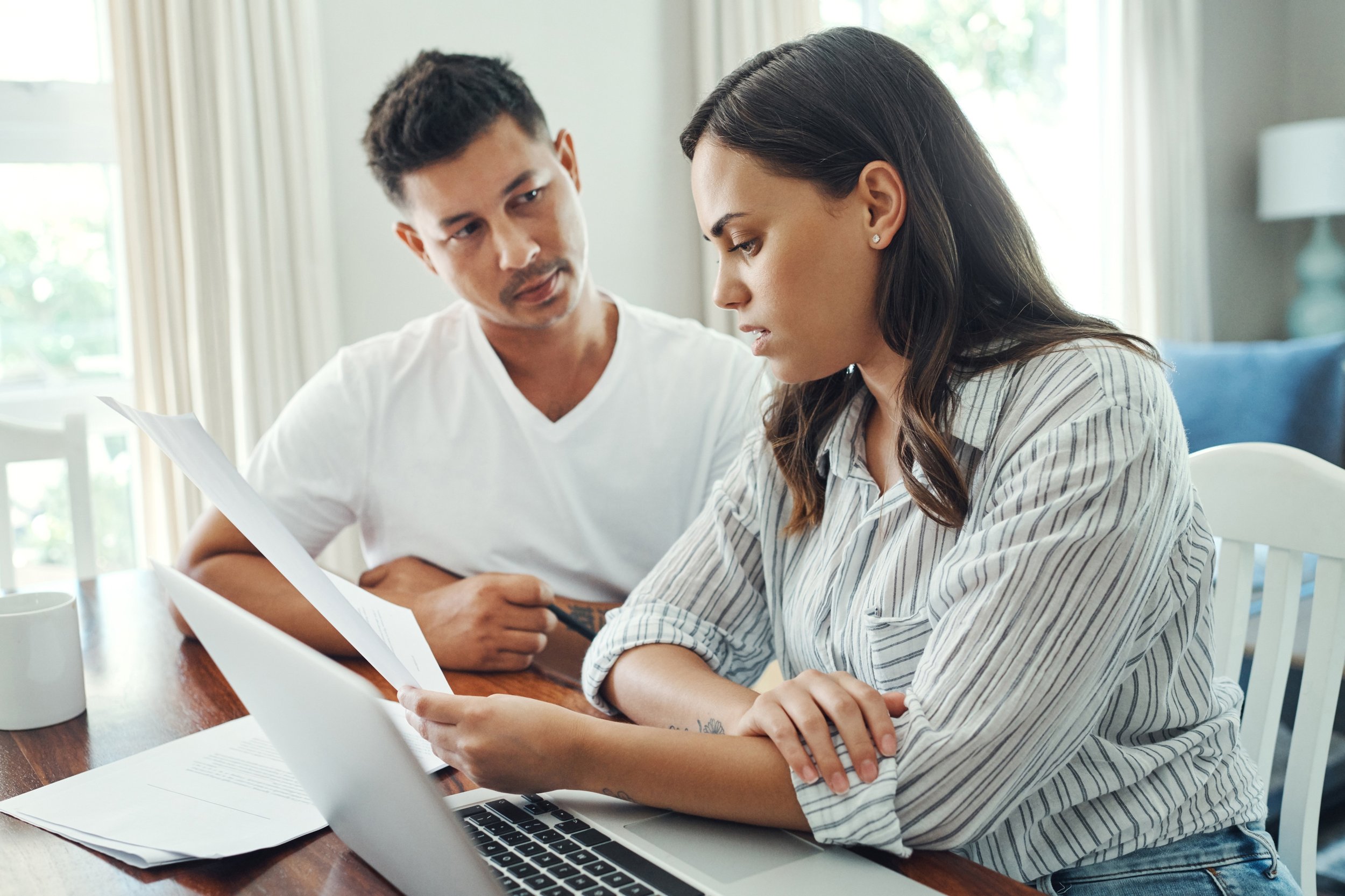 A couple sits together, reviewing paperwork.
