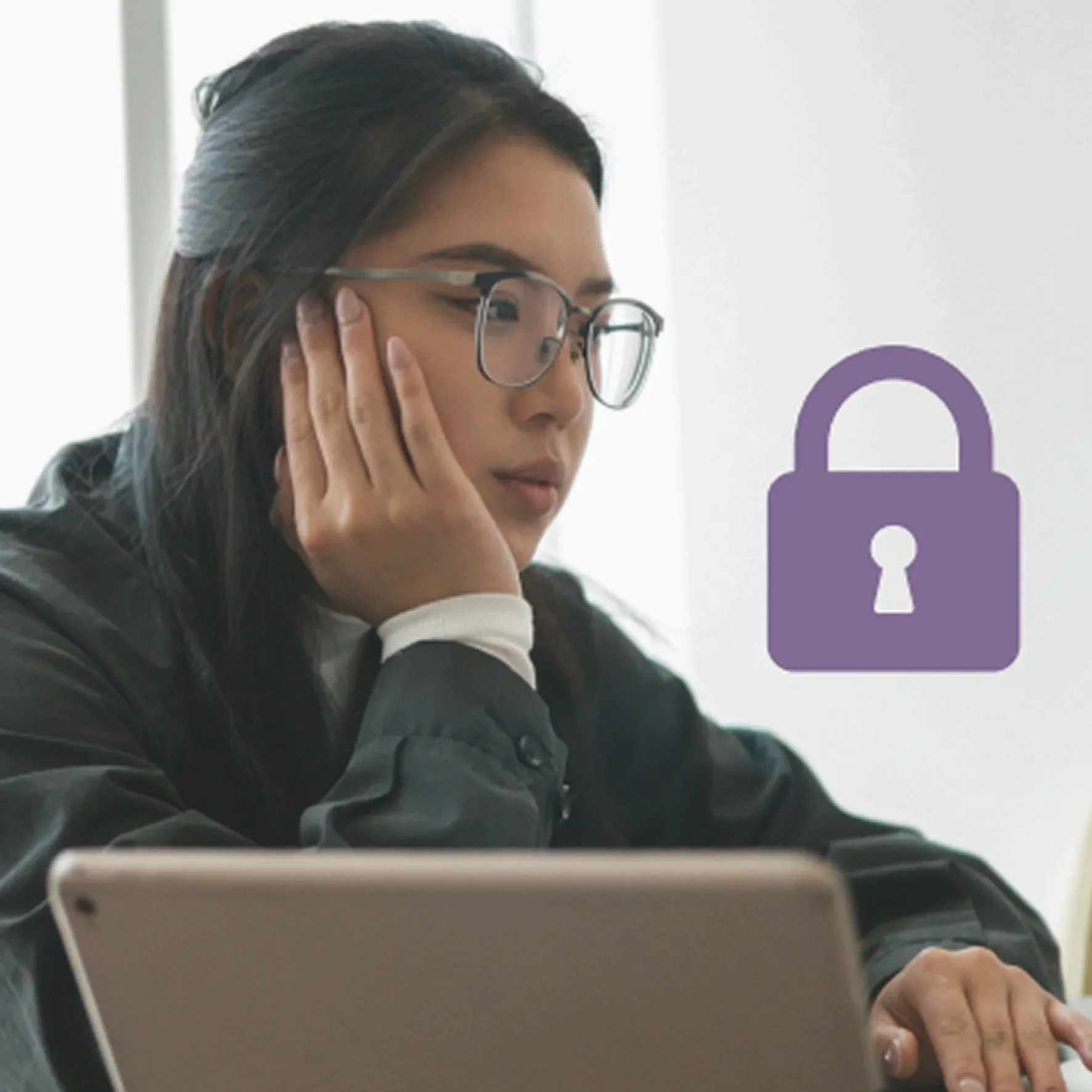 A woman with long, dark hair and glasses is resting her head on her hand, looking at a tablet or phone on a desk. There is a purple padlock icon in the background.