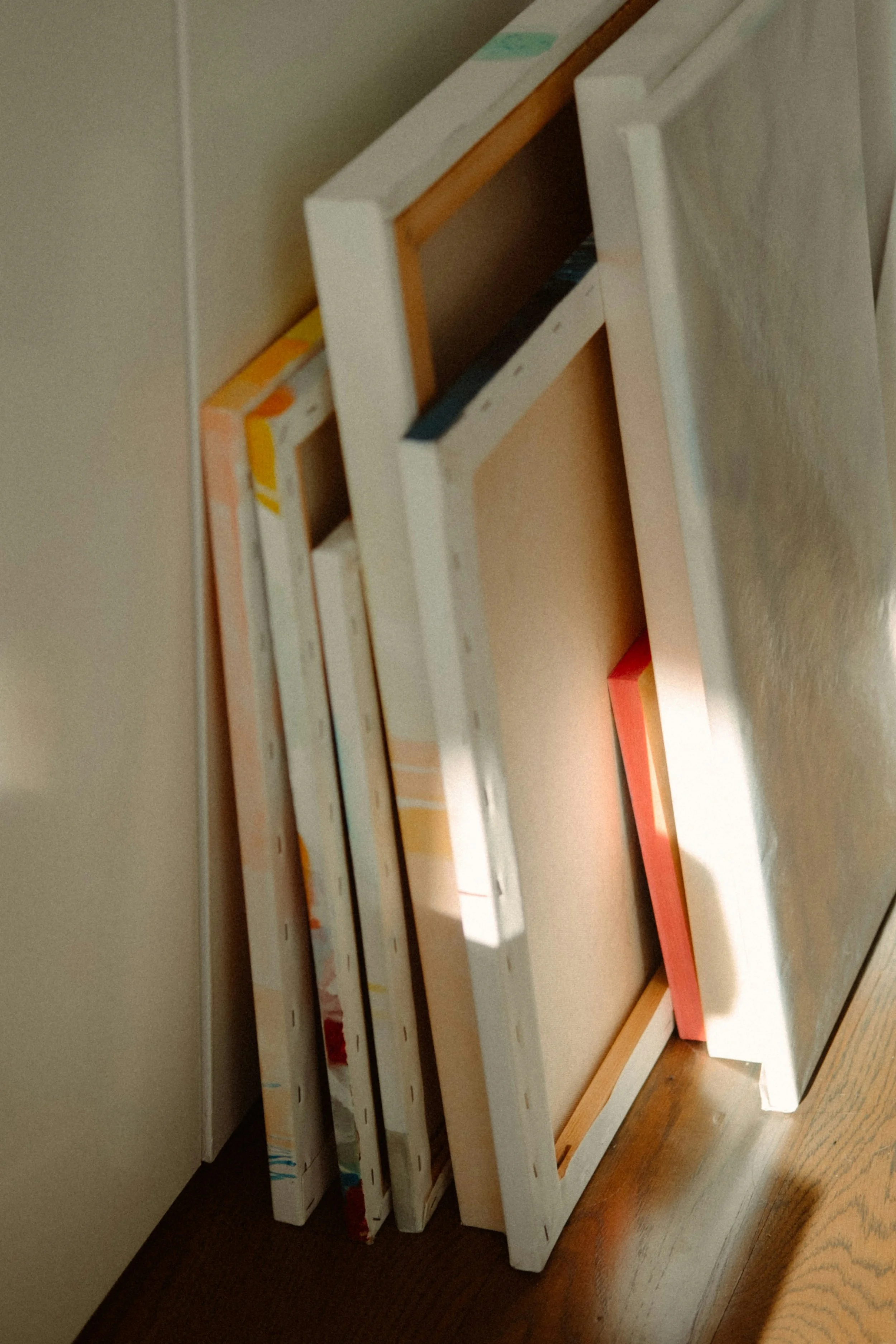 stack of canvases leaning on a wall
