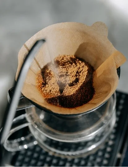 Coffee filter with used coffee grounds on a coffee dripper