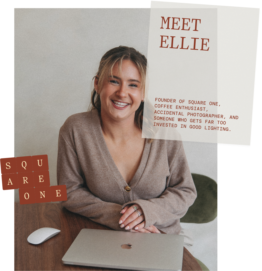 A woman smiling at the camera sitting at a table with a laptop and a computer mouse, with a sign behind her that reads "Meet Ellie" and a square one poster with the words "SQUARE ONE".