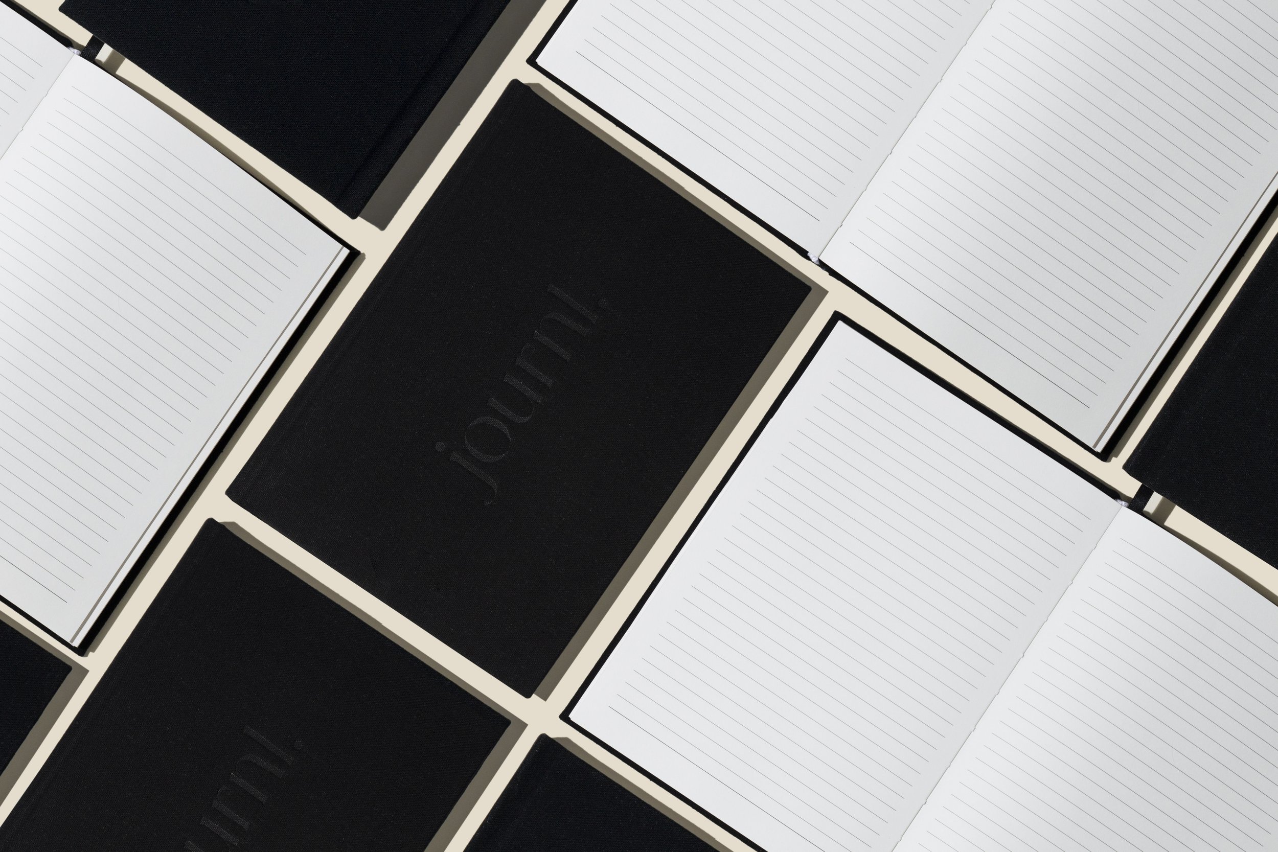 Multiple open notebooks with lined pages and black covers arranged in a pattern.