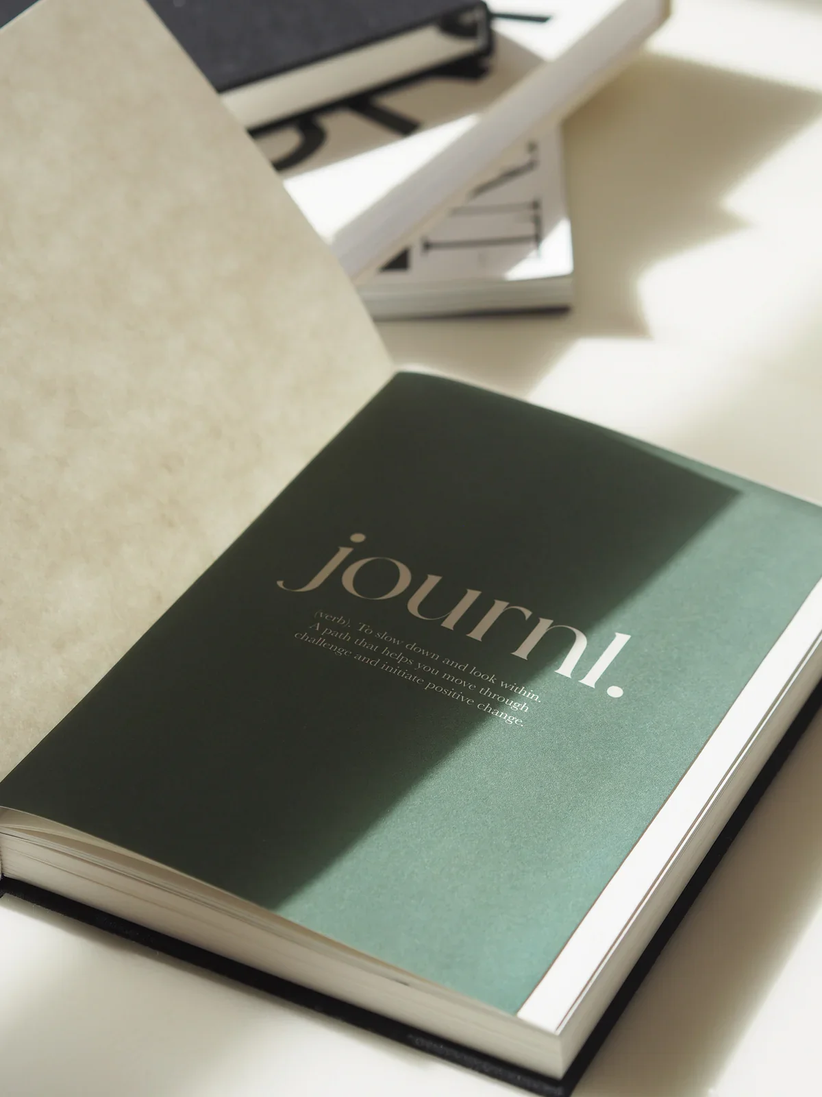 Open book with the word "journi." on the page, with a definition about traveling and creating positive change.