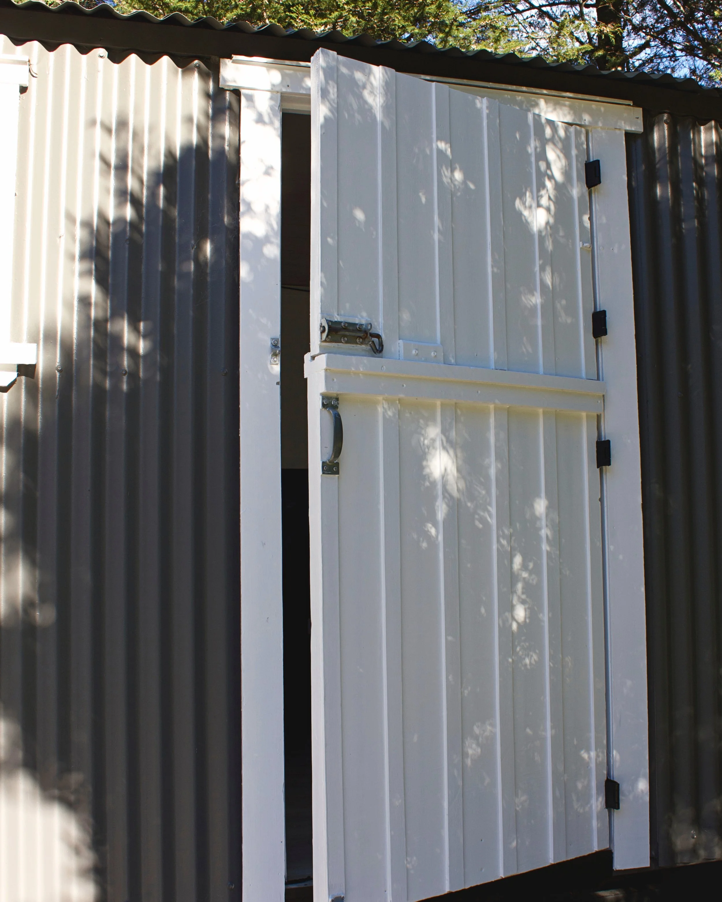 White entrance door of the renovated railway carriage cabin