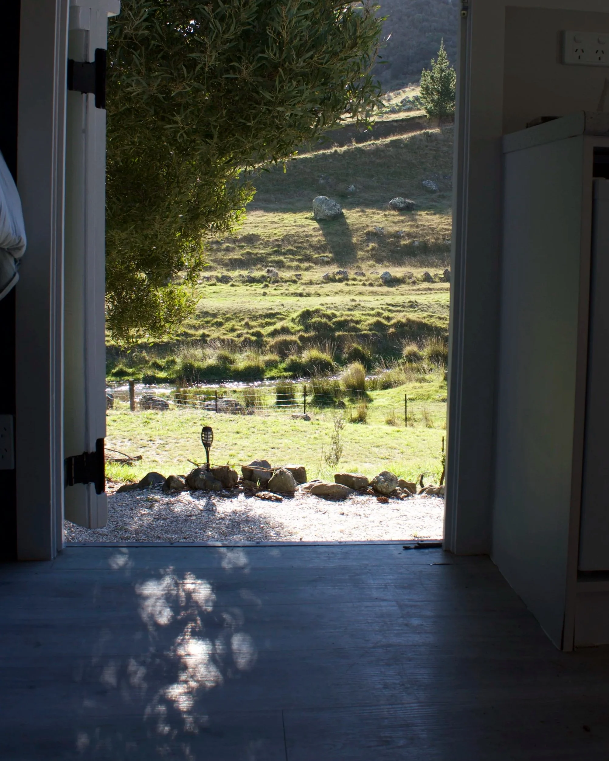 View of the Taylor River and surrounding hills through the open cabin doorway