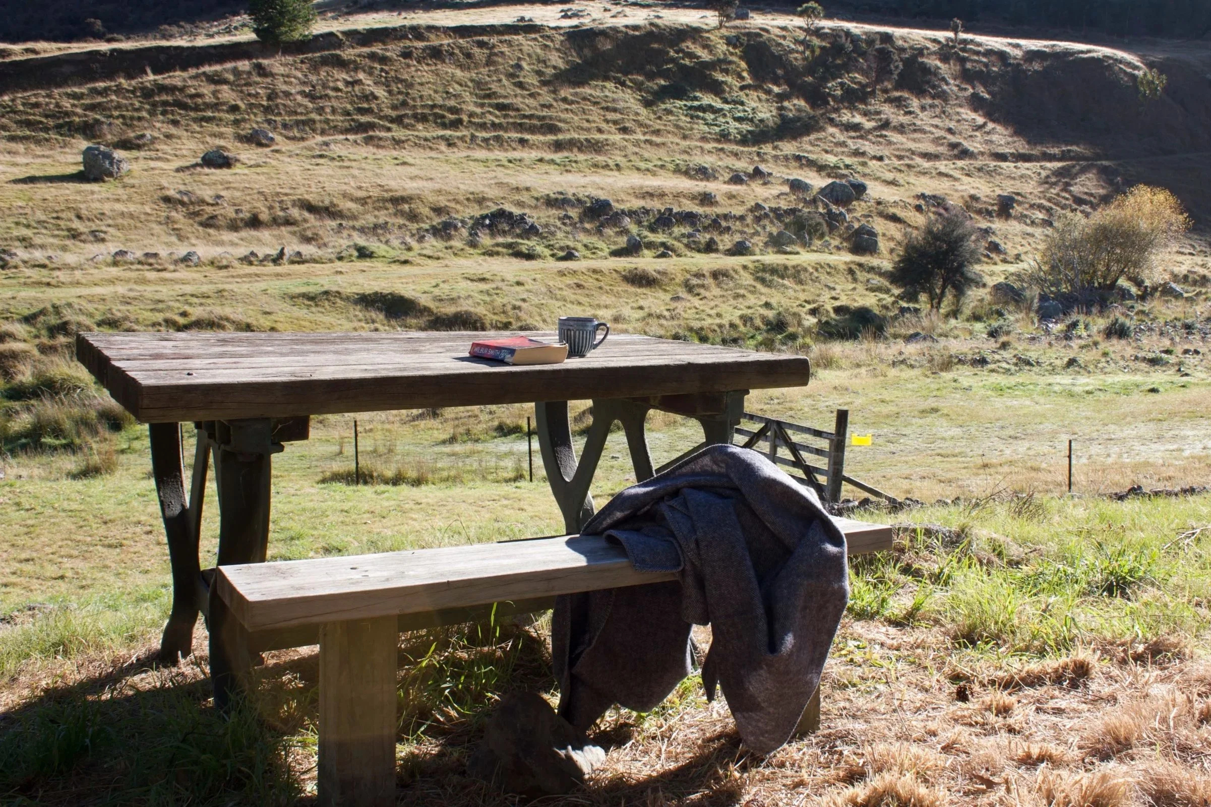 Outdoor picnic table overlooking the Taylor River and hills at Wildwood Estate