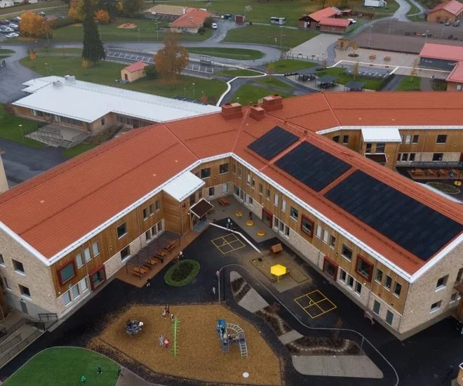 Flygbild av en skolbyggnad med gård och lekplats.