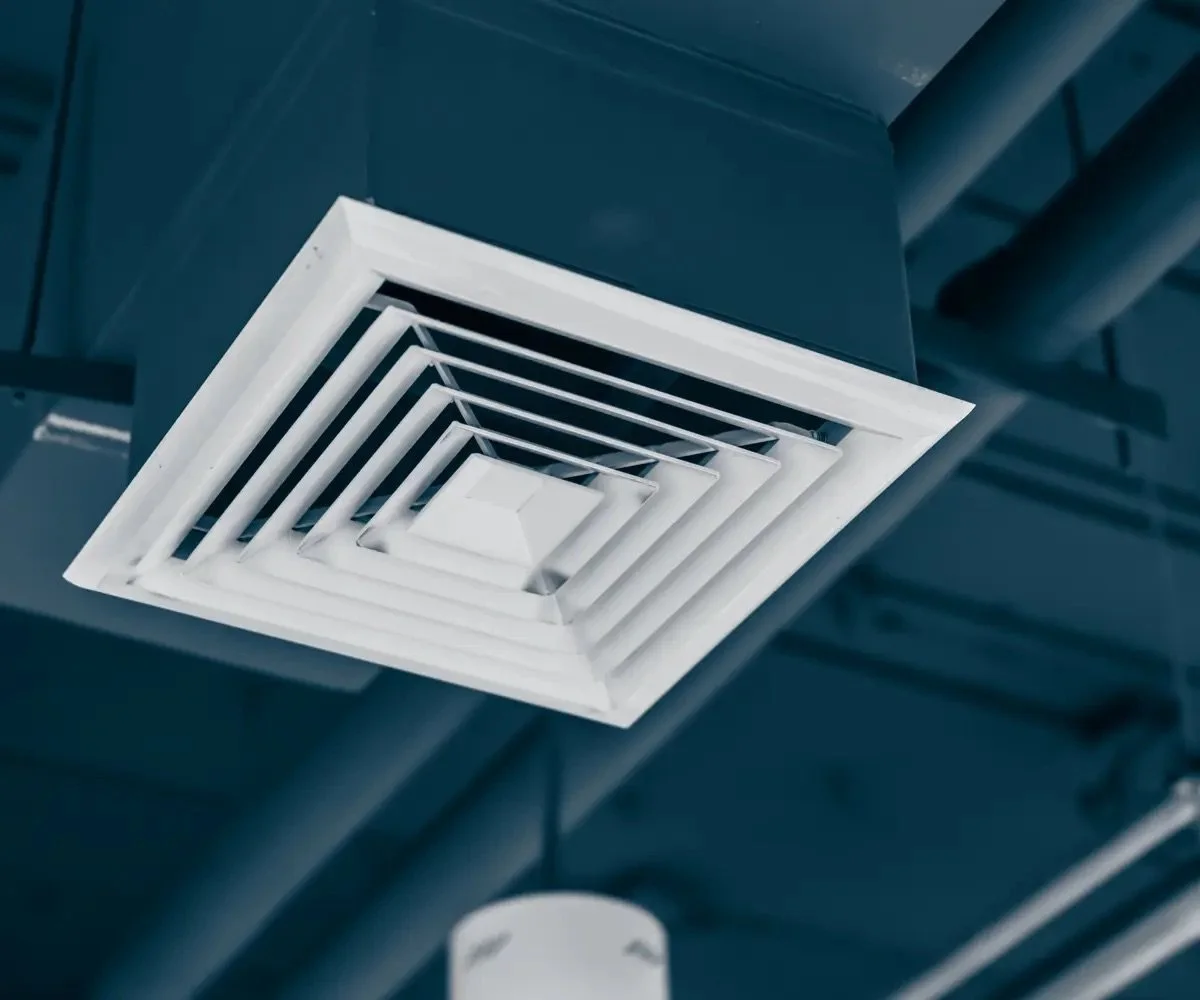 Ventilationsgaller i taket på industri- eller kommamiljö.