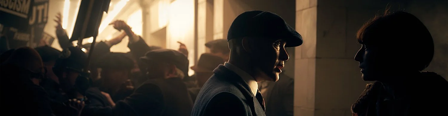 Silhouettes of a man and a woman facing each other in a dimly lit room, with a crowd of people in the background near bright windows.