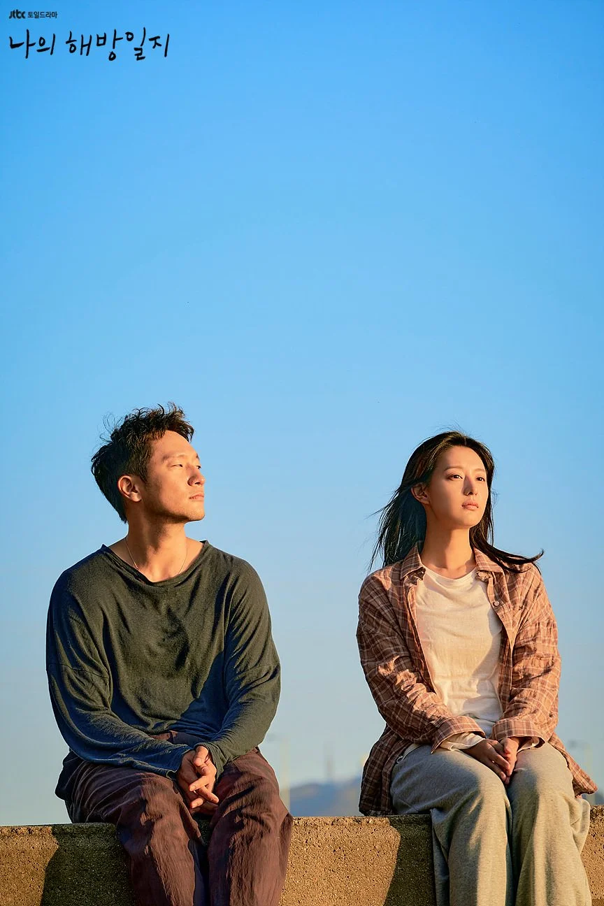 Mr. Gu and Yeom Mi-jeong sit side by side during a scene from the K-drama My Liberation notes