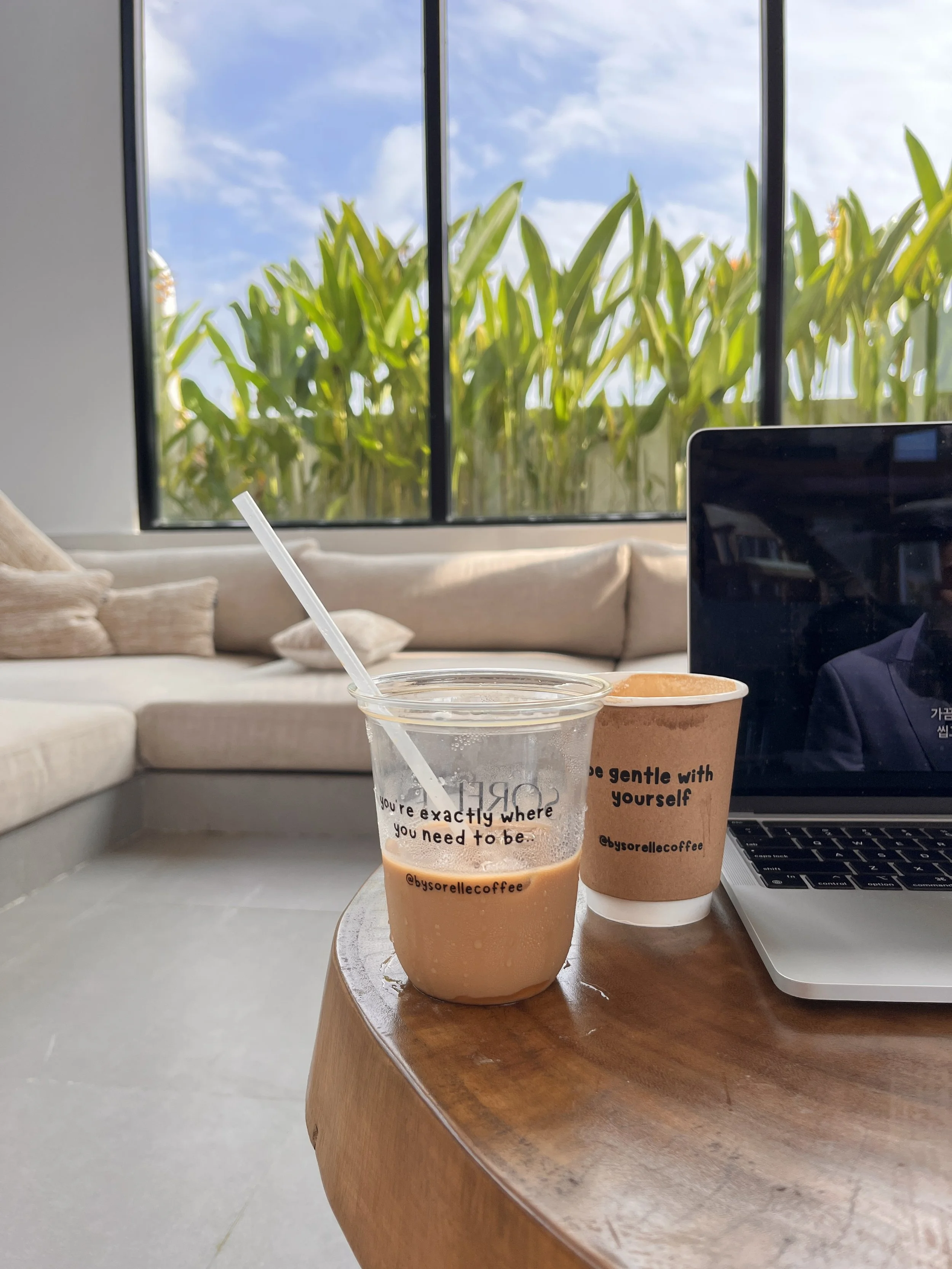 Coffee and a laptop on a wooden table in a living room in Bali