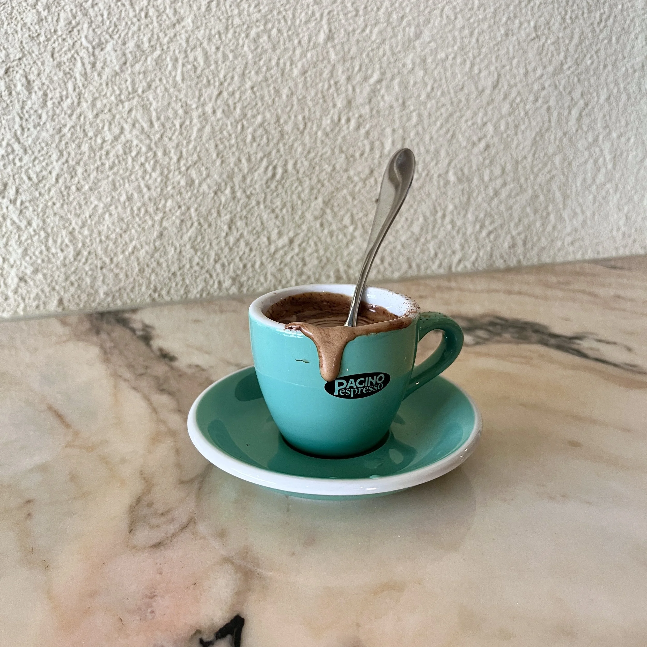 a cup of espresso with a spoon
