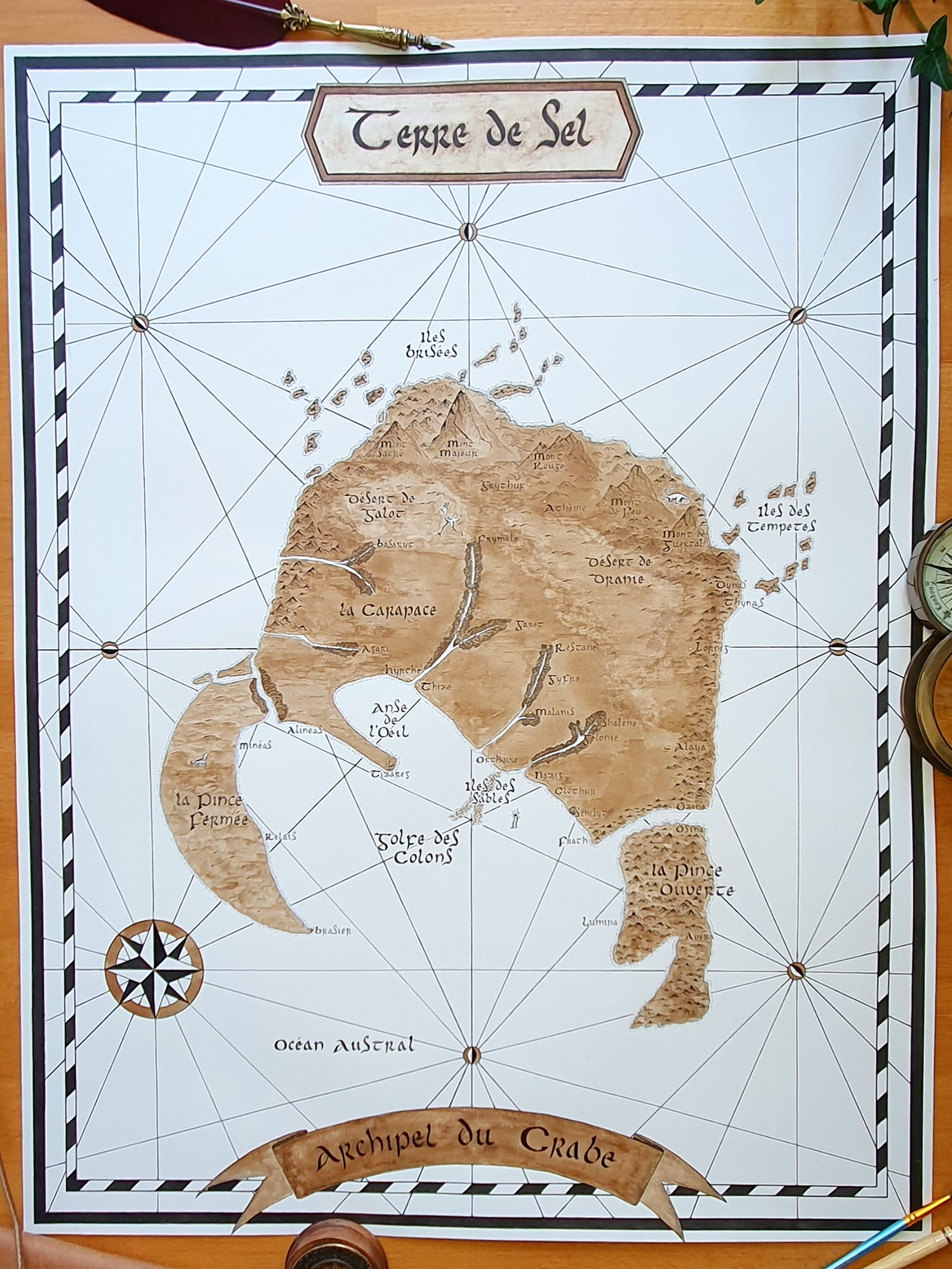 Carte ancienne de "Terre de Sel", du roman Éternité de Magali Segura, encadrée d'un motif noir et blanc, avec une boussole dans le coin inférieur gauche et une bannière en bas nommée "Archipel du Crabe".