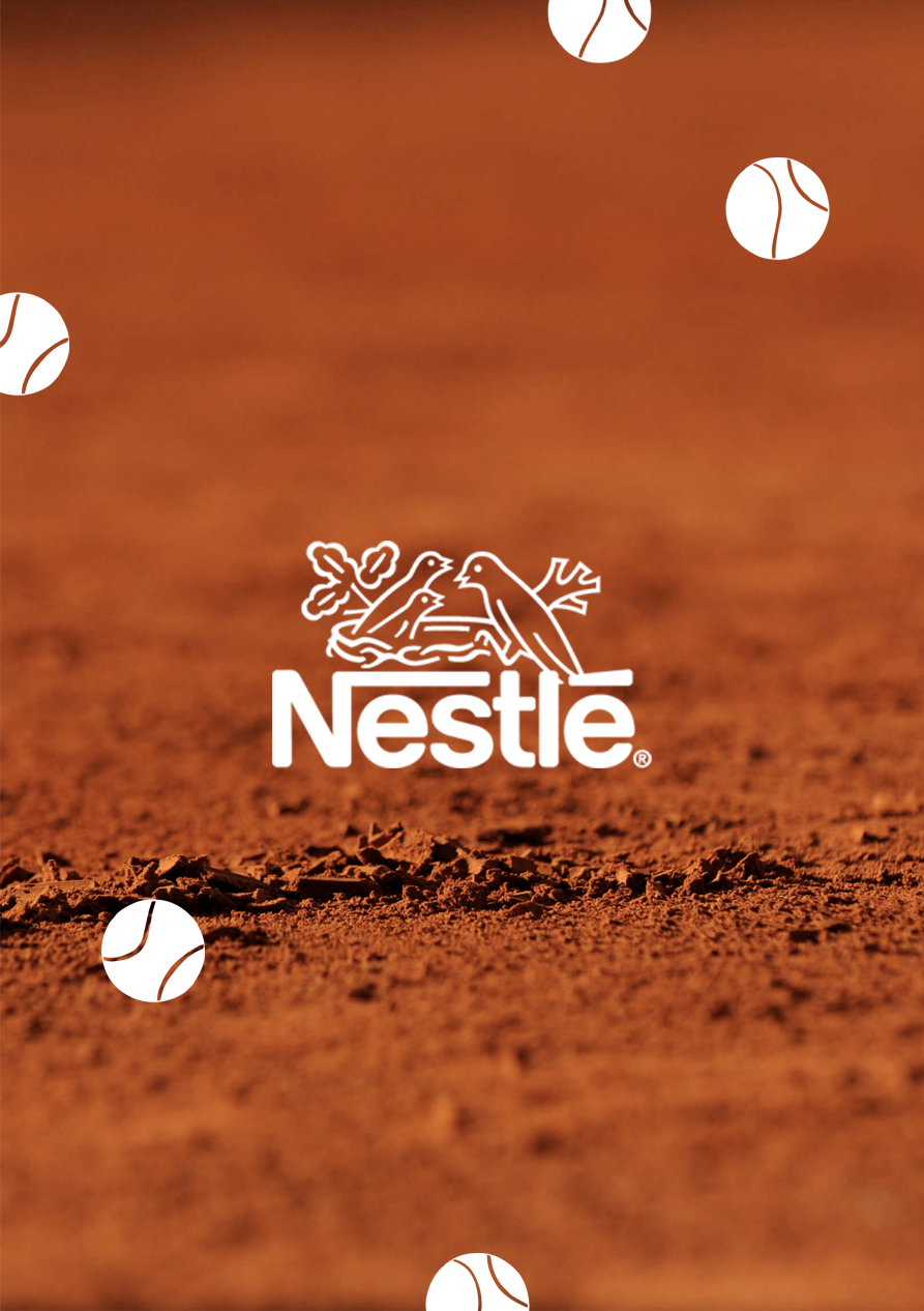 Gros plan d'une surface rougeâtre avec des balles de tennis blanches dispersées, et le logo de Nestlé au centre.