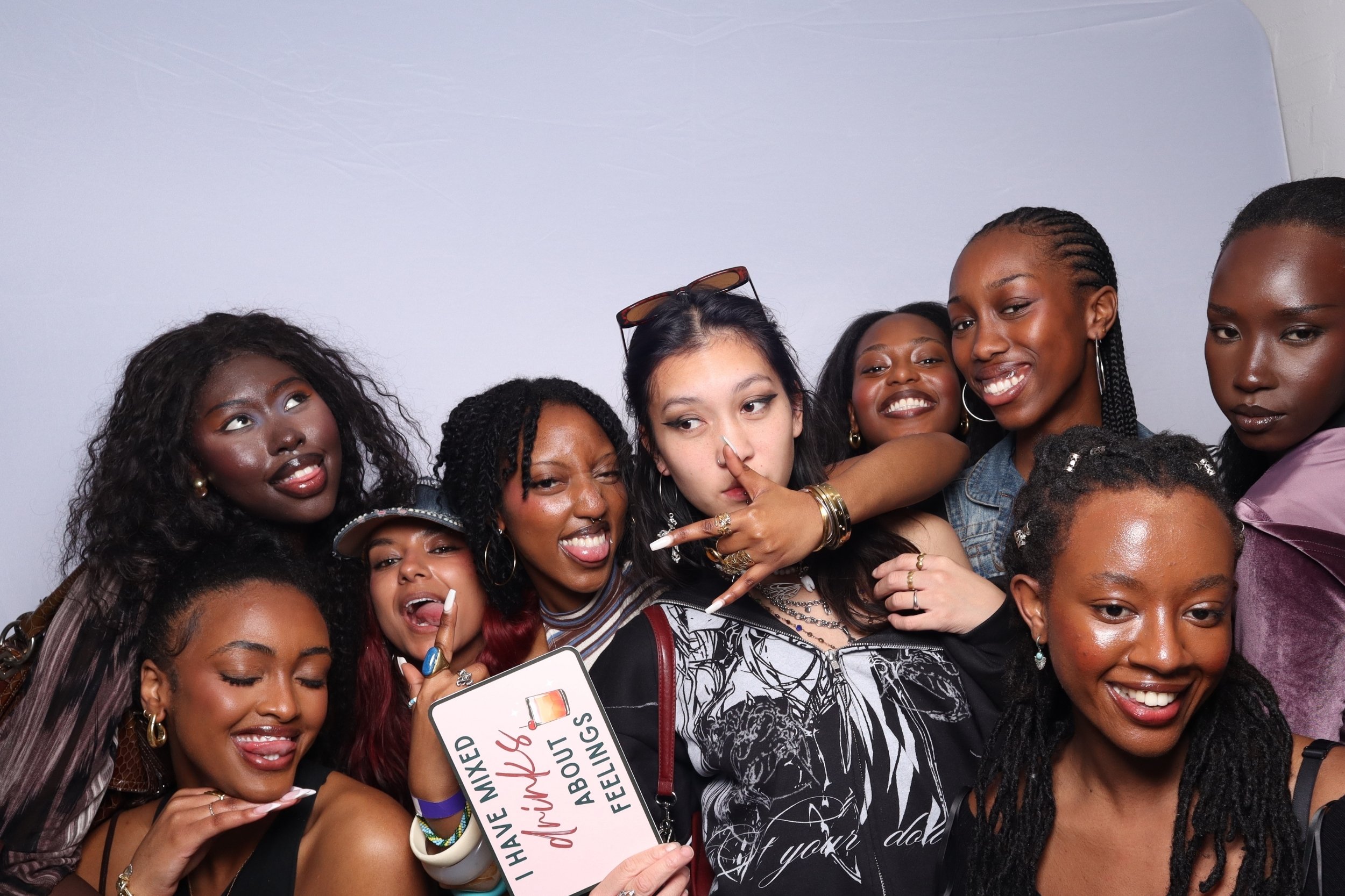 Group of party goers having fun, smiling and posing together at a social event, with some making peace signs and holding photobooth props fit for the soul event in 3danks sydney. Wide angled raw photography perfect for group shots in high quality.