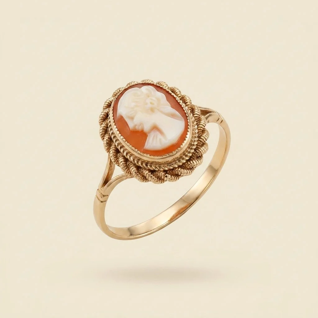 Gold ring with a carved cameo featuring a woman's profile set against a beige background.