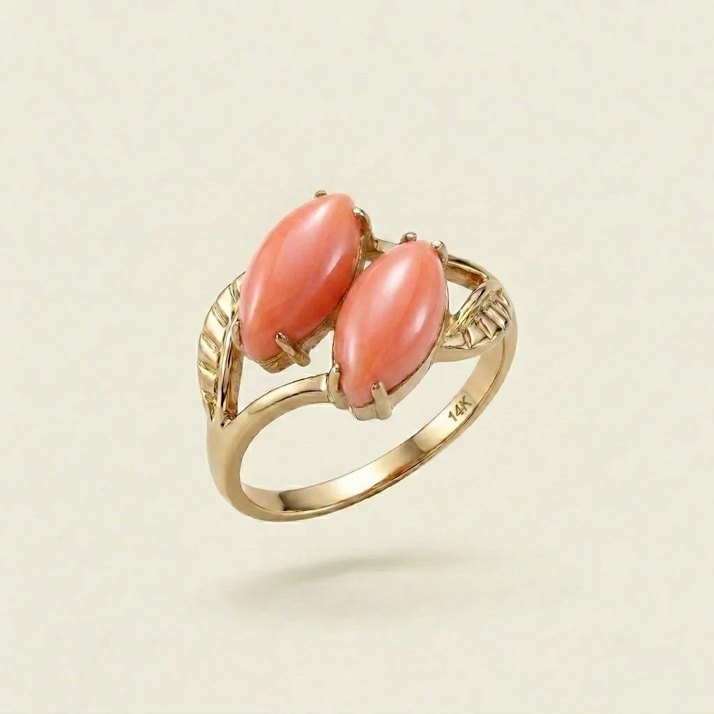 Gold ring with two oval pink stones set in a prong setting, featuring decorative twisted accents on the band.