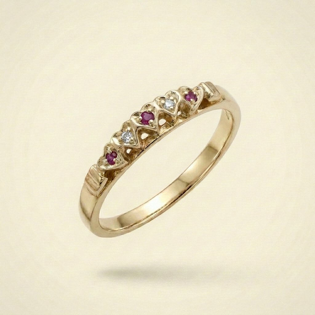 Gold ring with alternating small diamonds and rubies set in a heart-shaped pattern.