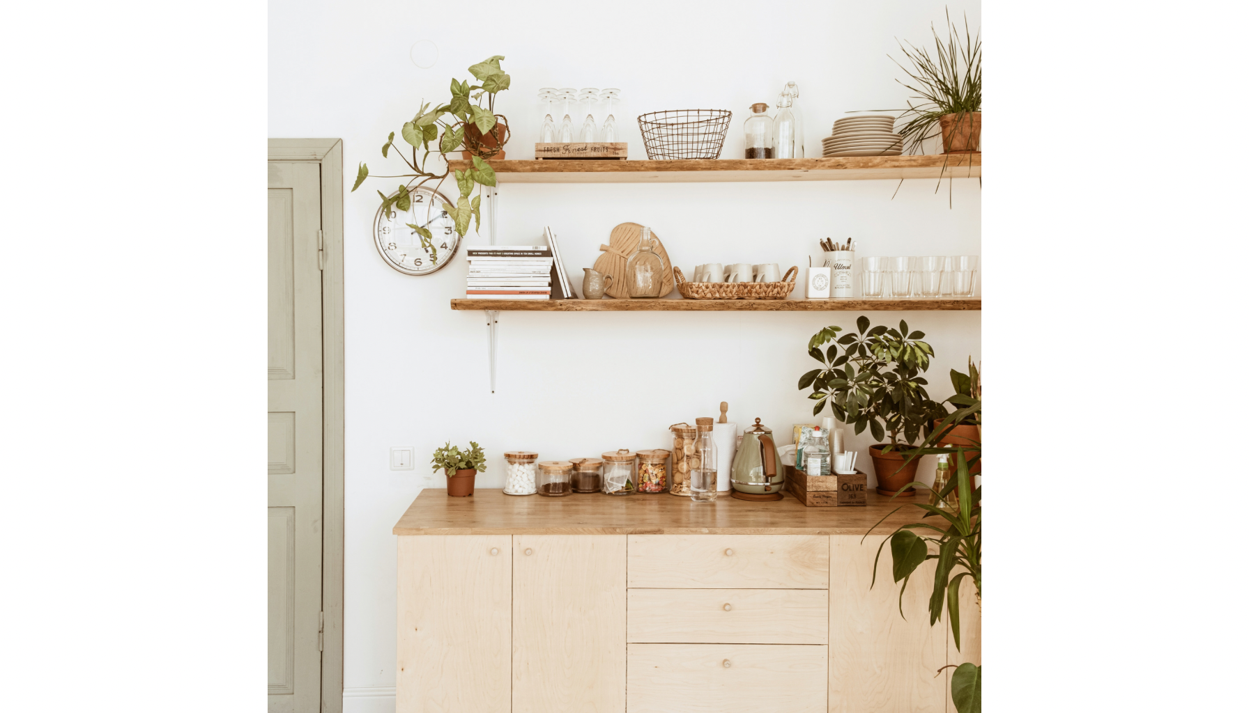 Hjemmekjøkken med to rustikke trebjelkerhylle med kjøkkenutstyr, bøker, glass og planter, samt en skap med skuffer under.