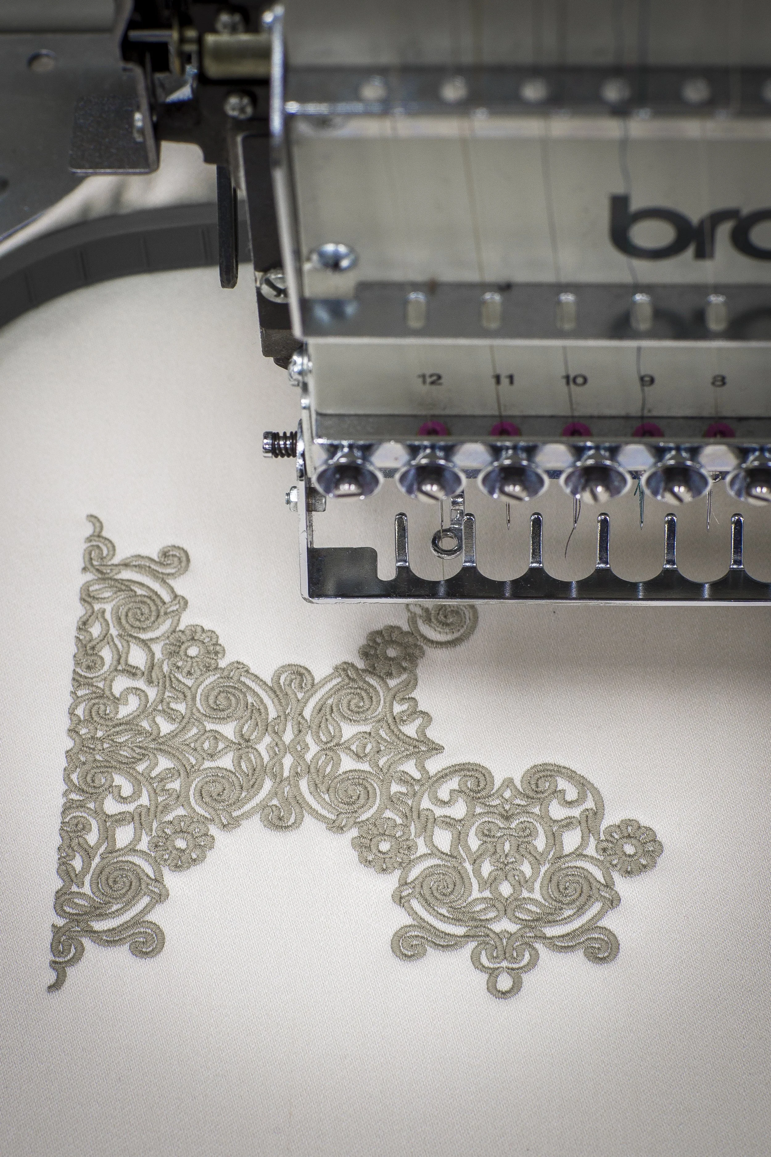 Close-up of beige embroidered Celtic knot pattern on white wool 