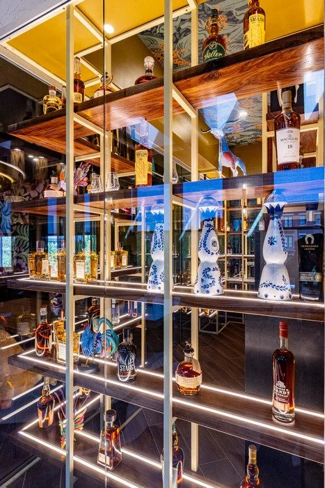 	
Gustavo's Mexican Grill -Custom tequila tasting room featuring handcrafted wood shelving designed to display liquor bottles and decorative ceramic vases, emphasizing warm wood tones, precise craftsmanship, and a refined presentation wall.