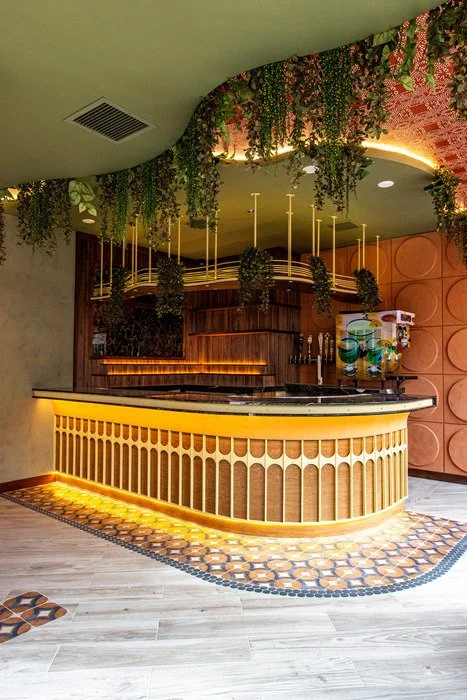 Gustavo's Mexican Grill - Louisville KY-Indoor bar showcasing a fully custom wood bar with curved detailing, featuring integrated wood shelving and decorative wood designs along the bar face.